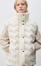Объемный стеганый жилет на пуху. Модель прямого кроя, с воротником стойкой и боковыми карманами. Застежка на молнию и кнопки под планкой.