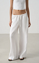 Широкие брюки из 100% льна. Модель свободного прямого кроя с врезными карманами по бокам. Изделие выполнено с поясом на узкой резинке, дополненным кулиской.