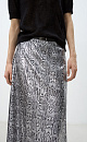 Юбка длины макси из текстурной ткани с анималистичным принтом, имитирующим чешую змеи. Изделие декорировано небольшими пайетками. Модель прямого силуэта. Застежка на молнию. На подкладке.