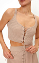 Короткий трикотажный топ из вискозы. Модель приталенного силуэта, без рукавов, на широких бретельках, с люверсами и шнуровкой на груди. Дополнить образ можно юбкой в таком же стиле.