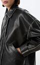 Куртка из рельефной экокожи. Модель прямого кроя, со спущенной линией плеч, отложным воротником, двумя карманами и регулируемой кулиской по низу. Застежка на молнию под планкой с кнопками. Изделие декорировано имитацией потертостей по швам и логотипом бренда на спине. На подкладке. 