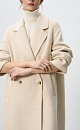 Двубортное шерстяное пальто свободного силуэта с английским воротником, боковыми карманами и застежкой на пуговицы.